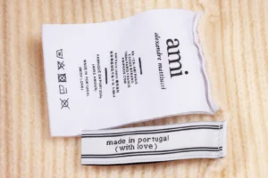 Label tags for Amiri unisex woven ADC stripes cardigan, featuring care instructions and "made in Portugal (with love)" text.