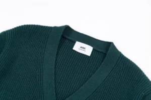 Dark green unisex v-neck sweater from Amiri, featuring ribbed texture and label detail, ideal for autumn and winter fashion.