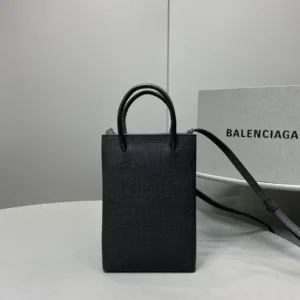 Mini black Balenciaga crossbody bag made of luxurious calf leather, featuring iconic logo and trendy design, displayed on a neutral background.