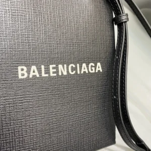 Mini Black Balenciaga crossbody bag featuring iconic logo, luxurious calf leather texture, and stylish design.