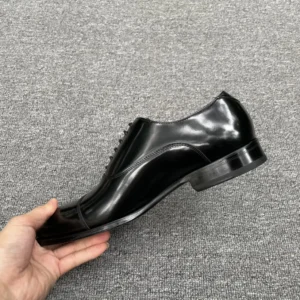 No brand or model visible black leather formal oxford dress shoe with cap toe and low heel
