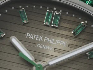 Patek Philippe Nautilus 5711 Diamond Set watch face featuring green emerald markers, silver hands, and brand logo, highlighting luxury craftsmanship.