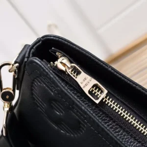 Close-up of the zipper and embossed detail on a black leather Louis Vuitton men's handbag, showcasing high-quality craftsmanship and elegant design features.