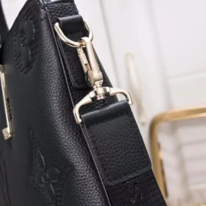 Detailed view of a black embossed leather Louis Vuitton Men's Bag Handheld strap and hardware, showcasing premium craftsmanship and design elements.