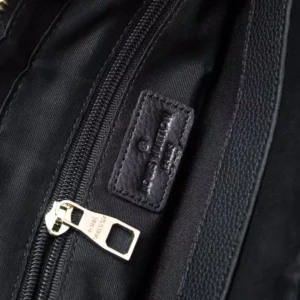 Close-up of the interior zipper and brand label of a Louis Vuitton men's bag, showcasing high-quality craftsmanship and embossed cowhide material.