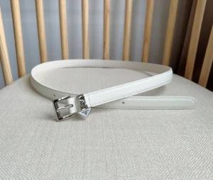 Elegant white Prada Saffia belt featuring a triangular metal logo decoration, displayed on a neutral fabric surface.