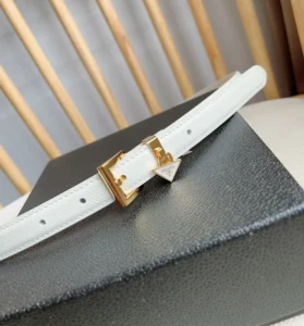 White PRADA belt with a triangular metal logo decoration and gold buckle, displayed on a black surface.
