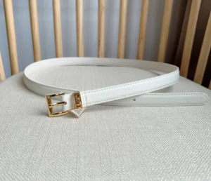 Elegant white PRADA belt with triangular gold logo decoration displayed on a neutral fabric surface.