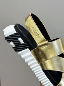Herm&egrave;s sandal gold metallic leather upper black white rubber sole with embossed logo strap