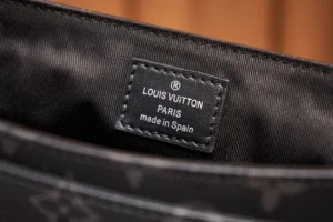 Louis Vuitton tag inside messenger bag, featuring brand logo, "PARIS," and "made in Spain," highlighting authenticity and craftsmanship in luxury replica goods.