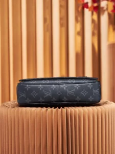 Louis Vuitton messenger bag in Monogram Eclipse canvas, showcasing brand logo and sleek design, displayed on textured surface.