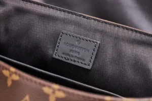 Interior view of Louis Vuitton messenger bag showing brand label and monogram canvas pattern.