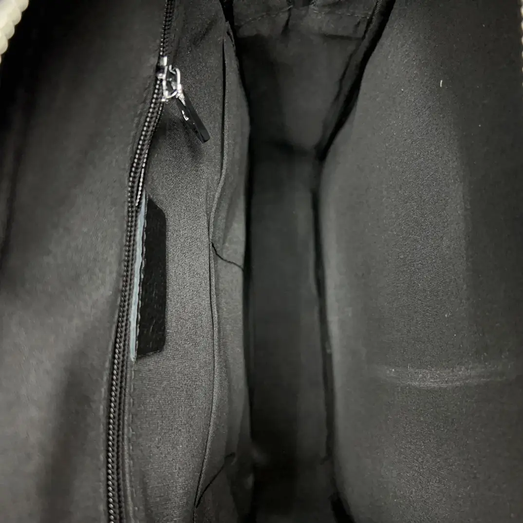 Chanel Classic Flap Medium black leather handbag interior with zip pocket and fabric lining