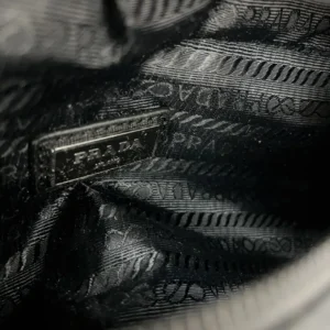 Interior view of PRADA Re Nylon Waist Bag showcasing brand label and fabric texture, emphasizing luxury craftsmanship and design details.