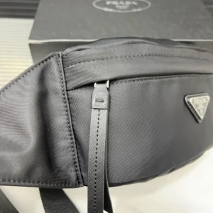 PRADA Re Nylon waist bag showcasing sleek black design, featuring logo detail and zipper closure, with packaging box in background.