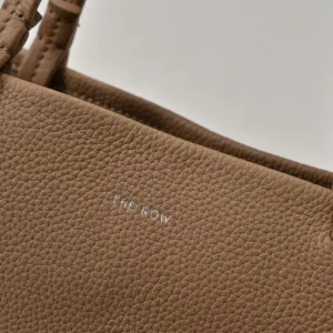 The Row Park tote close-up showcasing textured lychee patterned cowhide and embossed logo.