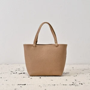 The Row Park tote bag in soft lychee patterned cowhide, minimalist design, neutral beige color, suitable for hand or diagonal carry.