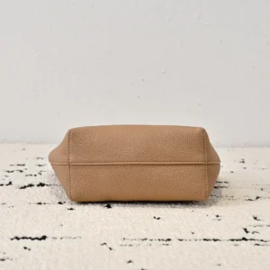 Bottom view of The Row Park tote bag showcasing its minimalist design and textured cowhide material, set against a light-colored surface.