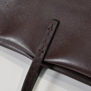 Close-up of Therow Nuance Sheepskin Tote Bag in dark brown leather, featuring minimalist design and soft texture, highlighting craftsmanship and quality.