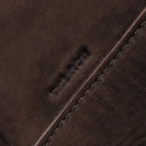 The Row embossed logo on soft, dark brown calf leather, showcasing the luxurious texture and quality of the Saddle leather shoulder bag.