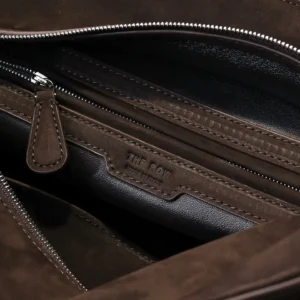 Interior view of The Row Saddle leather shoulder bag, featuring soft, glossy calf leather, zipper compartment, and brand label.