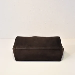 The Row Saddle leather black shoulder bag with silver buckle, showcasing soft, glossy calf leather texture.