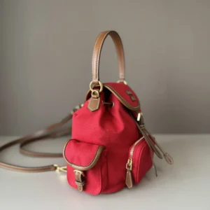 MIU New College Style Backpack in red with leather accents, featuring a multi-pocket design and adjustable shoulder strap, showcasing casual yet stylish craftsmanship.