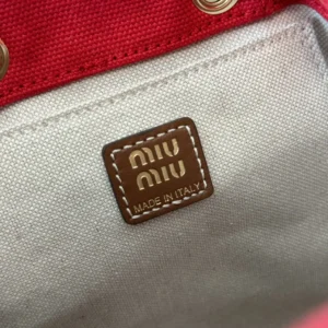 MIU MIU leather backpack tag featuring "MIU MIU" logo and "MADE IN ITALY" inscription, highlighting craftsmanship and brand authenticity.