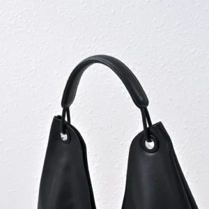 The Row Ascot small black leather handbag with rounded handle and silver grommet details
