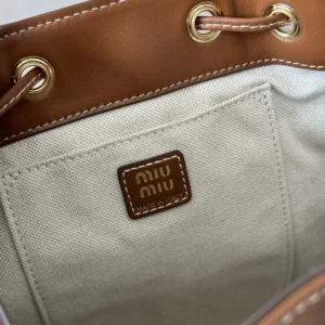 Interior view of MIU MIU New College Style Backpack showcasing leather trim, linen blend lining, and logo tag.
