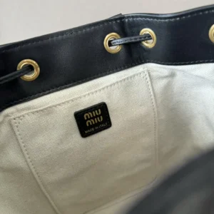 Interior view of MIU MIU New College Style Backpack showcasing the logo tag, leather trim, and durable linen blend lining.