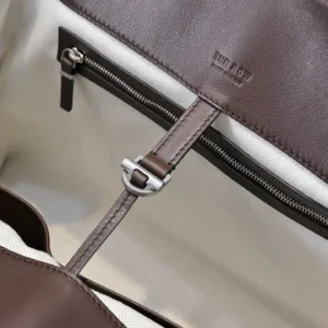 Interior view of The Row Marlo Tote in black, showcasing leather texture, zipper details, and brand logo.