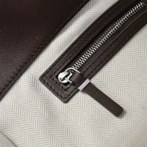 Close-up of The Row Marlo Tote's zipper detail, featuring durable saddle leather and a textured interior lining, highlighting craftsmanship and luxury design elements.