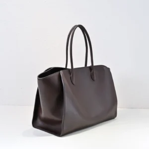 The Row Marlo Tote in black, featuring a sleek design and durable saddle leather, ideal for luxury accessory enthusiasts.