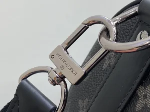 Louis Vuitton bag silver metal clasp black leather strap textured canvas material close-up