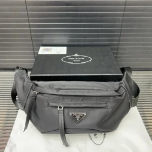 Prada nylon cloth waist bag in black with logo, displayed with packaging, highlighting its design and luxury appeal.