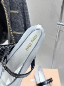 Miu Miu Hollow Weaving Ballet Shoes featuring soft mesh fabric, black strap, and logo detail, showcased in a stylish setting.