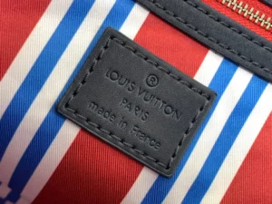 Louis Vuitton bag interior label made in France on red, white, and blue striped fabric lining