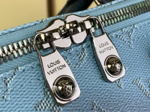 Louis Vuitton zipper puller hardware on textured blue monogram canvas bag with silver metal finish