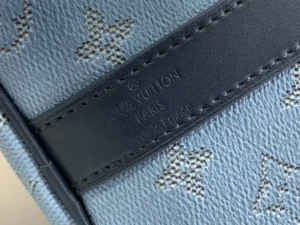 Louis Vuitton bag close-up with black leather strap and monogram canvas material in grey and brown details