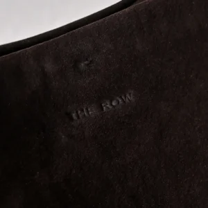 The Row suede black leather material close-up detail with embossed logo