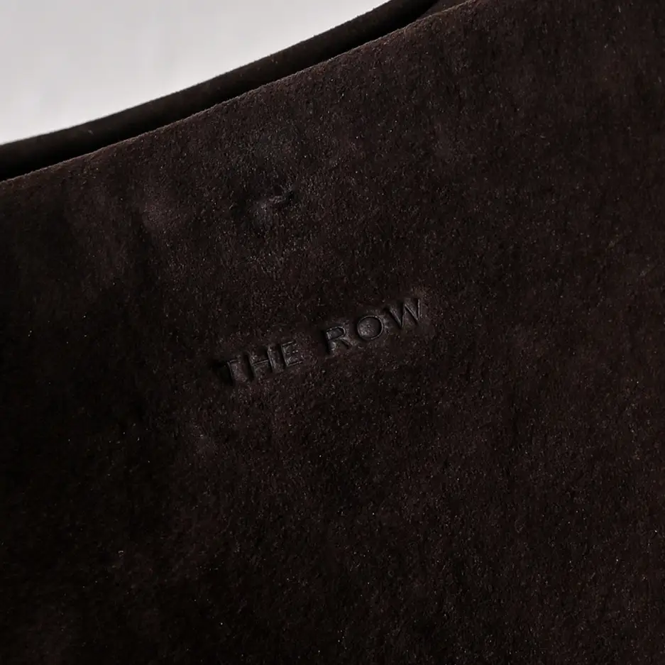 The Row suede black leather material close-up detail with embossed logo