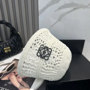 LOEWE Summer Fisherman's Hat in white crochet design with decorative logo, displayed alongside a black Miu Miu handbag.