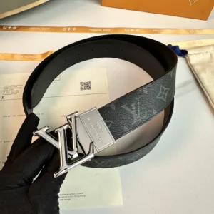 L0UIS VUITT0N Donkey Men's Belt featuring a black canvas design with silver logo buckle, displayed on a surface with packaging materials.