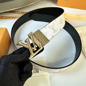 L0UIS VUITT0N Donkey Men’s Belt with gold-tone logo buckle, featuring classic canvas design and calf leather lining, held by a gloved hand.