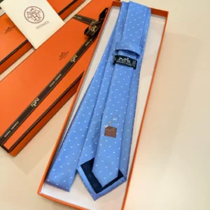 Hermès Letter Men's Tie in blue with polka dots, presented in an orange Hermès box, showcasing luxury fashion accessory.