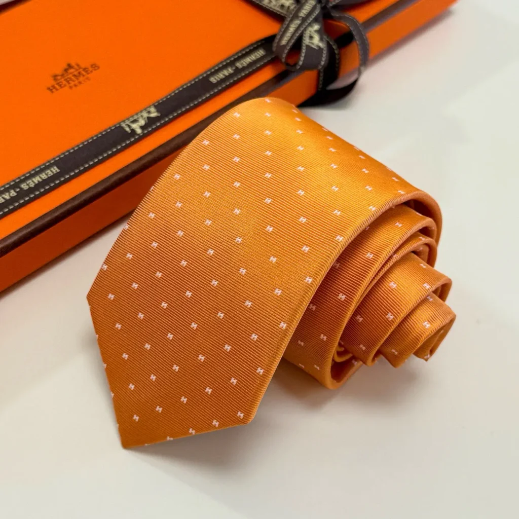 Hermes silk tie orange color with white pattern made from premium silk fabric