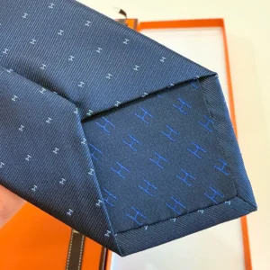 Hermès silk tie navy blue pattern woven fabric luxury accessory with branded logo detail