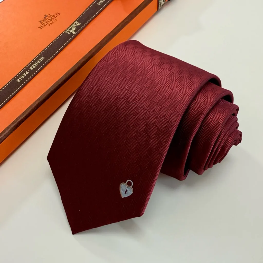 Hermes tie dark red silk with subtle check pattern and small heart lock embroidery detail