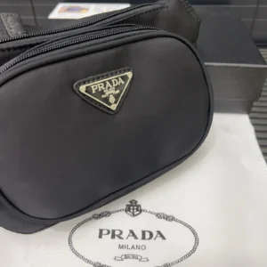 Prada Nylon Waist Bag featuring logo emblem on black fabric, displayed on a Prada branded dust bag.